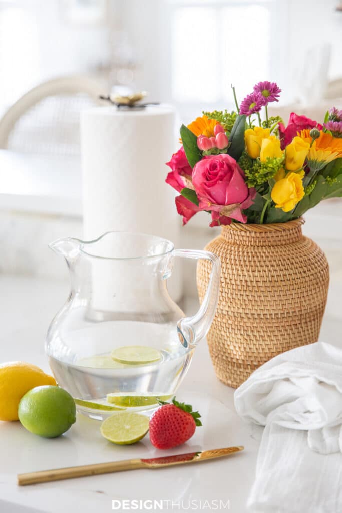 pitcher of water with flowers and fruit