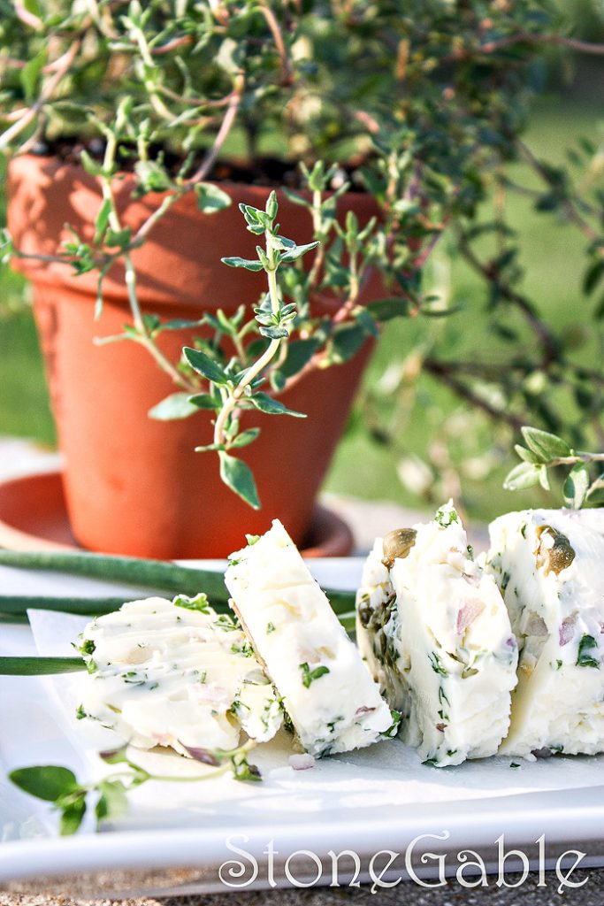 HERB BUTTER LOG SLICED ON A WHITE PLATE