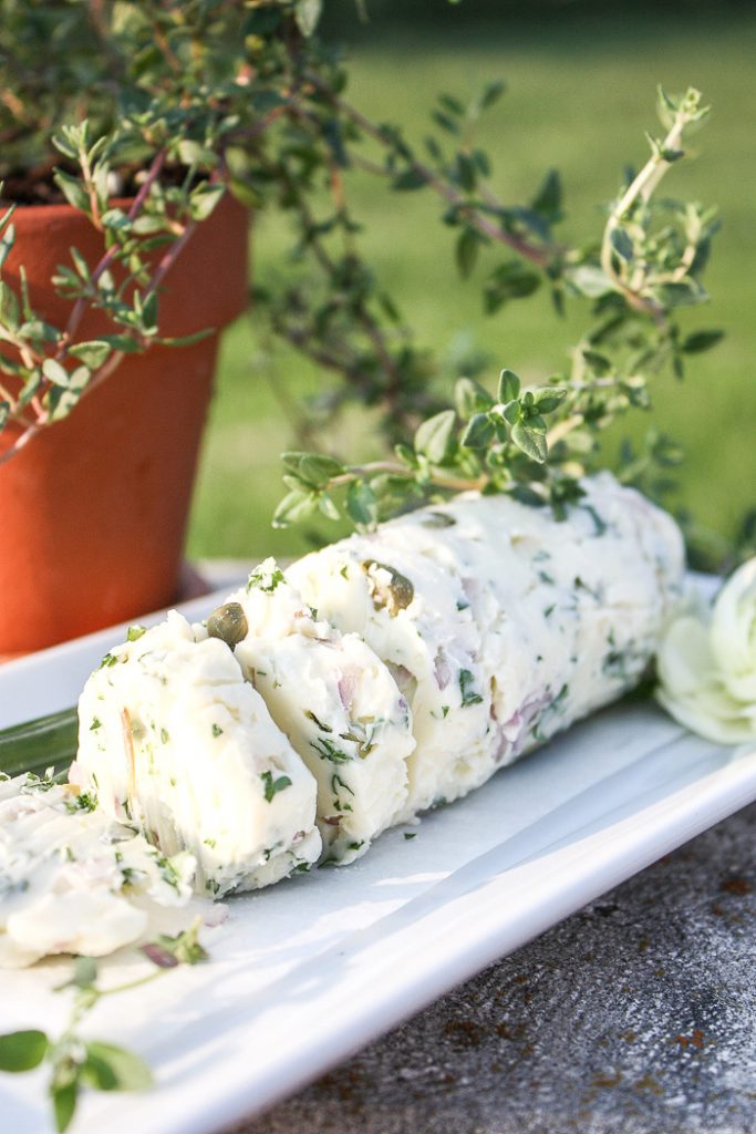 HERB BUTTER ON A BENCH WITH A POT OF THYME BEHIND IT