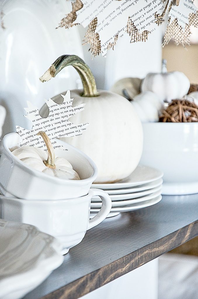 WHITE PUMPKINS ON A SHELF WITH WHITE DISHES