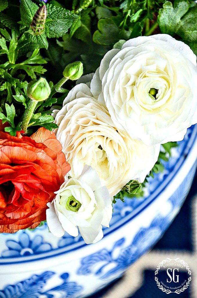 orange and white flowers in a blue and white pot