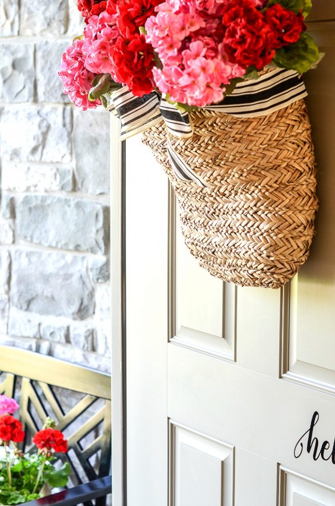 BASKET OF FLOWERS ON AN OPEN FRONT DOOR