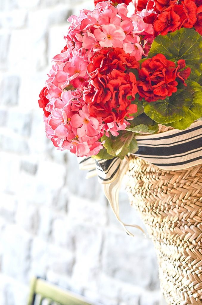 BASKET OF PINK AND RED GERANIUMS ON THE FRONT DOOR