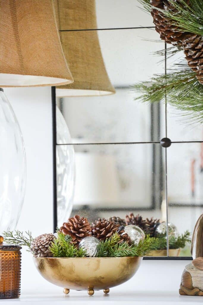 greens, pinecones and ornaments in a gold bowl