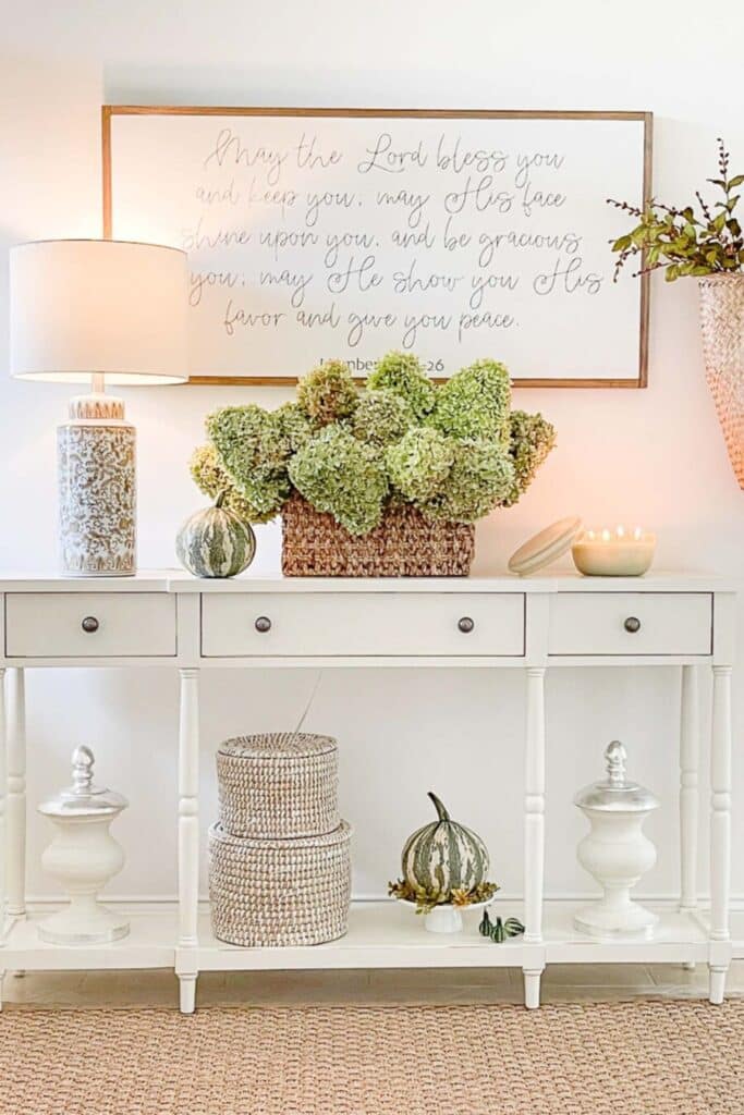 fall foyer ideas- green hydrangeas in a basket on a fall console