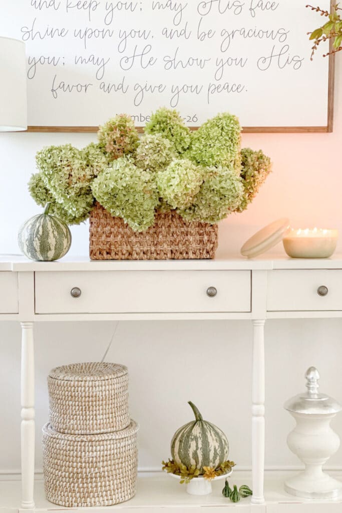 fall foyer ideas- green hydrangeas in a basket on a fall console