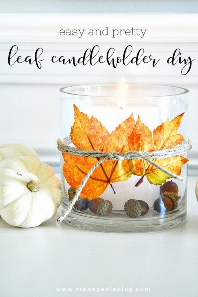 A clear candleholder with a leaf tied with twin around the outside of it