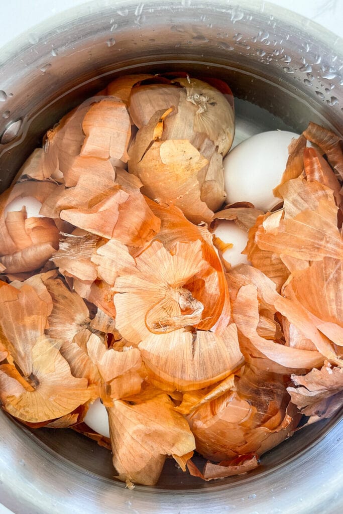 ONION SKINS AND EGGS IN WATER IN A SAUCEPAN