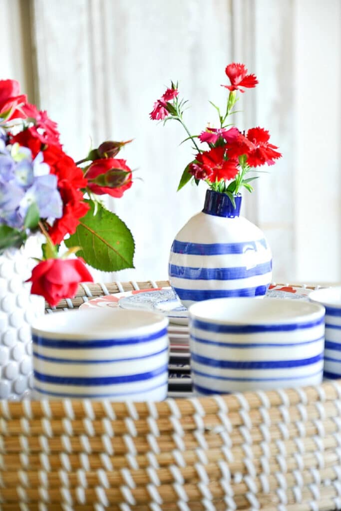 red, white and blue patriotic centerpiece in a basket with two small American flags