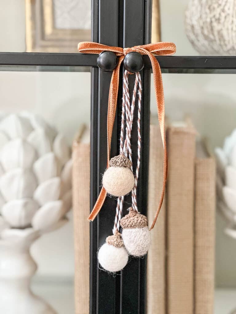 ACORNS HANGING ON A METAL DOOR WITH A VELVET BOW